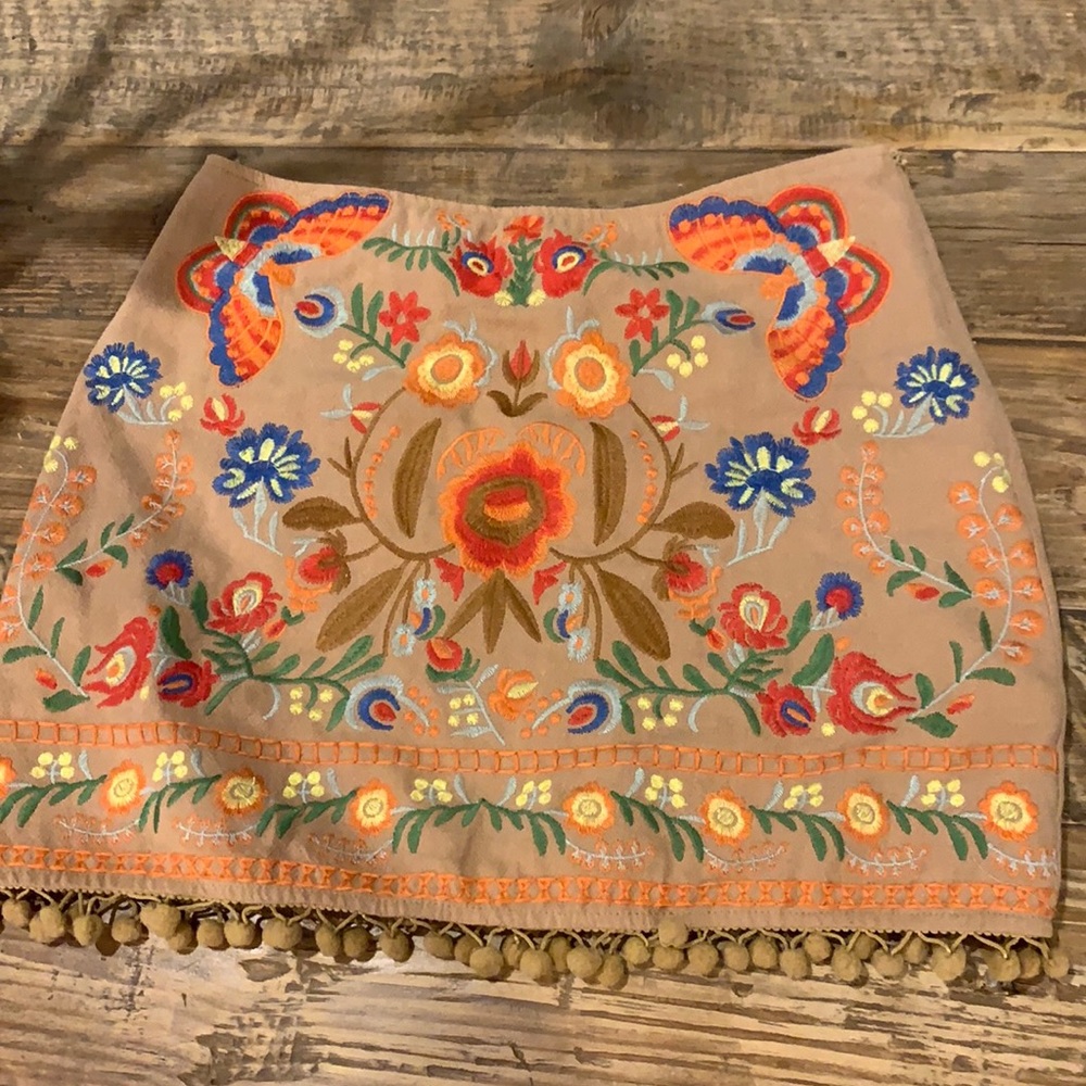 Umgee short tan skirt with colorful embroidery.